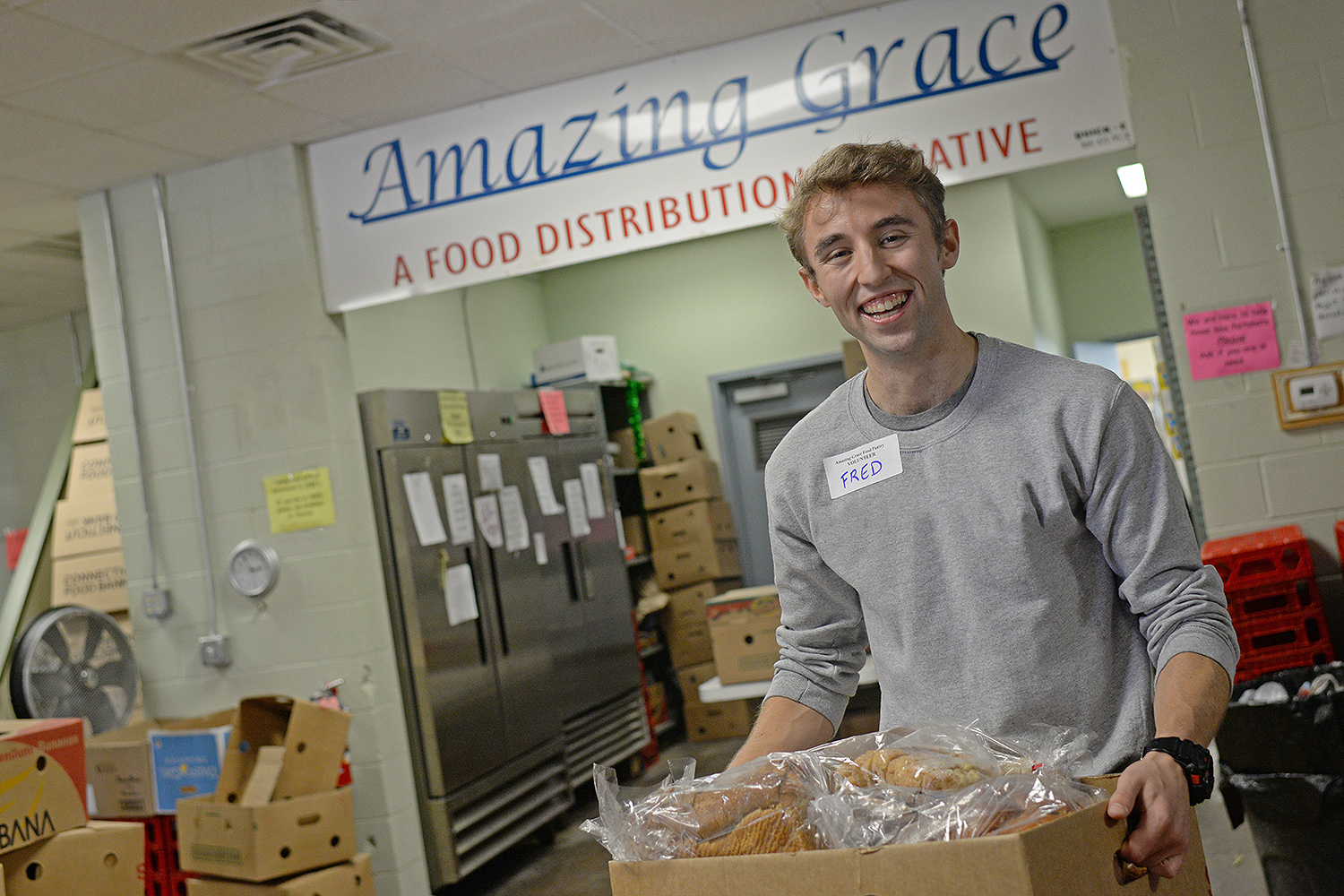 Fred Ayres '17 helps stock shelves at Amazing Grace Food Pantry in Middletown on Oct. 4. Ayers is one of several Wesleyan students and alumni who are volunteering at the food pantry this month.