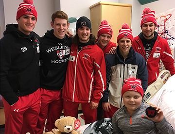 Hockey players visit Connor in the hospital. 