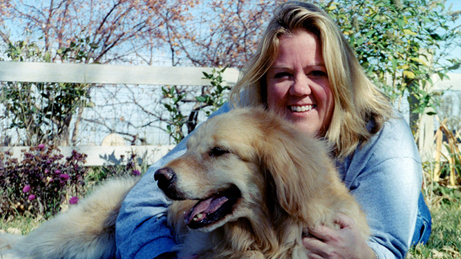Laura Fraser's sister Jan, smiling, with her arms around her dog, Sunny.