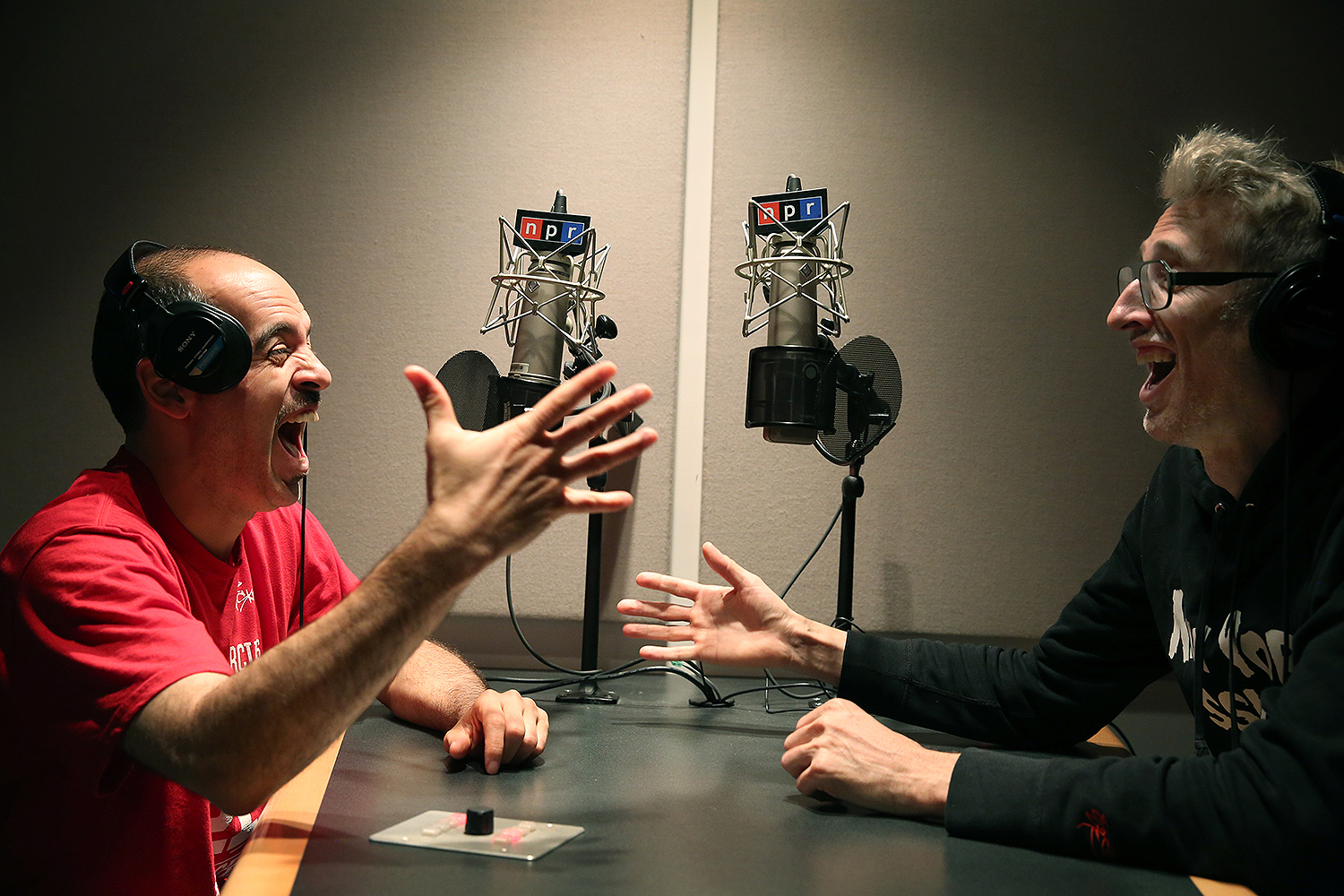 Bobbito Garcia and DJ Stretch Armstrong are in animated discussion and laughter across a studio table on the air at NPR.