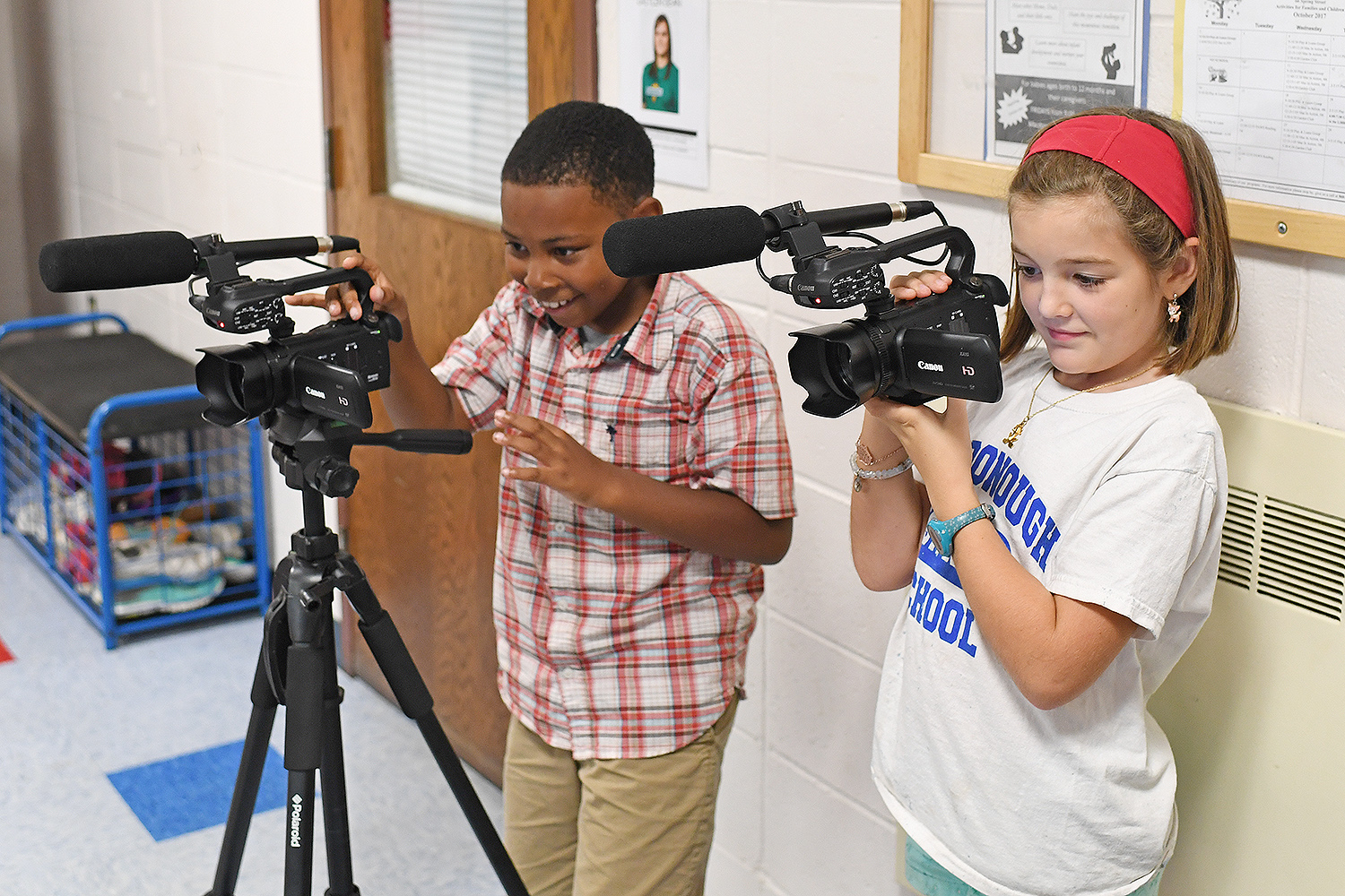 Isaiah and Violet practice using the Canon videocameras. 