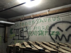 While searching the tunnels underneath the Foss student residences, the group encountered graffiti lettering reading, “Clobbersaurus was here." Underneath was a wooden pallet box containing the Glyptodon‘s shell replica.