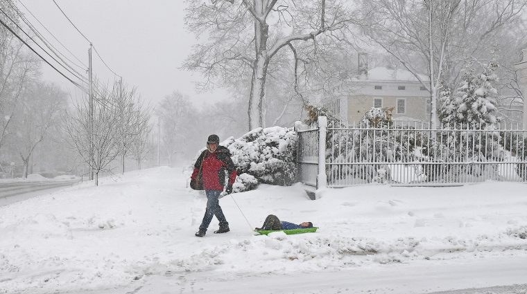 Emmanuel Paris-Bouvet, director of language resources and technology and visiting instructor in romance languages and literatures, pulls his son, Lucas, down Wyllys Ave. in a sled. (Photo by Olivia Drake)