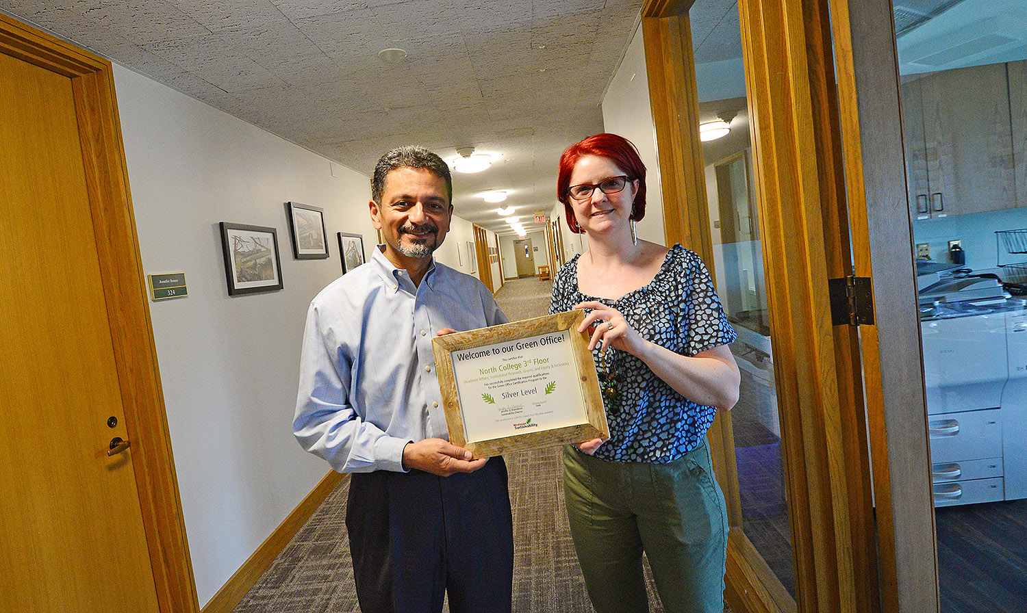 Antonio Farias, vice president for equity and inclusion, and Megan Flagg, executive assistant to the provost and vice president for academic affairs, proudly display their Green Office Certification on the third floor of North College. The third floor is the first space on campus to be Green Office Certified by the Sustainability Office.