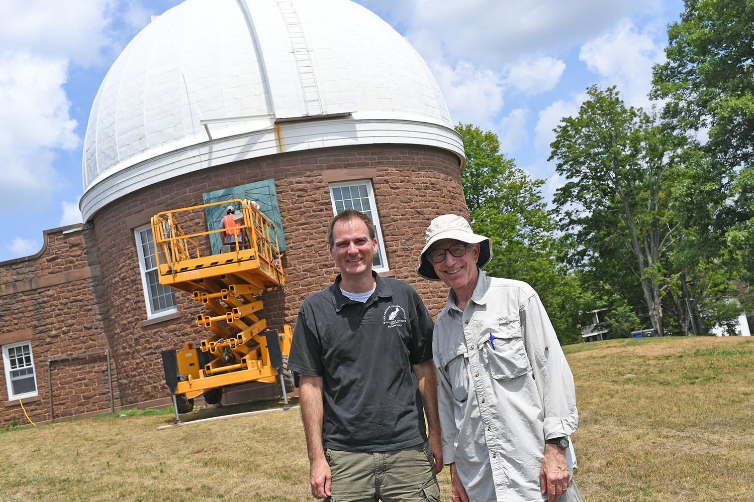 Seth Redfield, chair and associate professor of astronomy, associate professor of integrative sciences, and artist Robert Adzema observe a sundial's installation July 16 at the Van Vleck Observatory. Adzema, a maker of site-specific sundials, designed the sculpture to be placed at its exact location on the telescope's wall.
