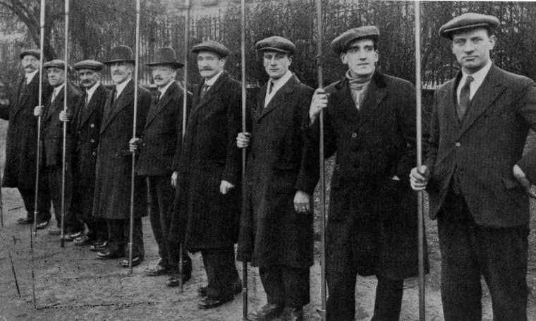 A team of British lamplighters pose with their poles c. 1930. (Chris Sugg, CC BY-SA)
