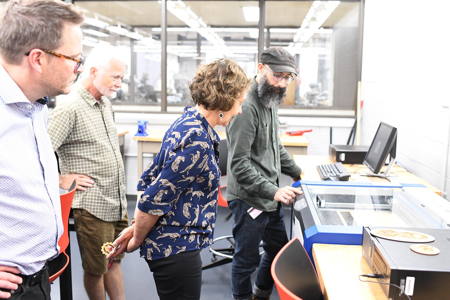 Lopez demonstrates how a laser cuts an object out of wood. 