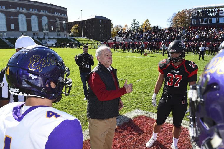 Williams and Wesleyan face off for the coin toss, with alumnus Jeff Diamond ’70 at center, doing the toss. 