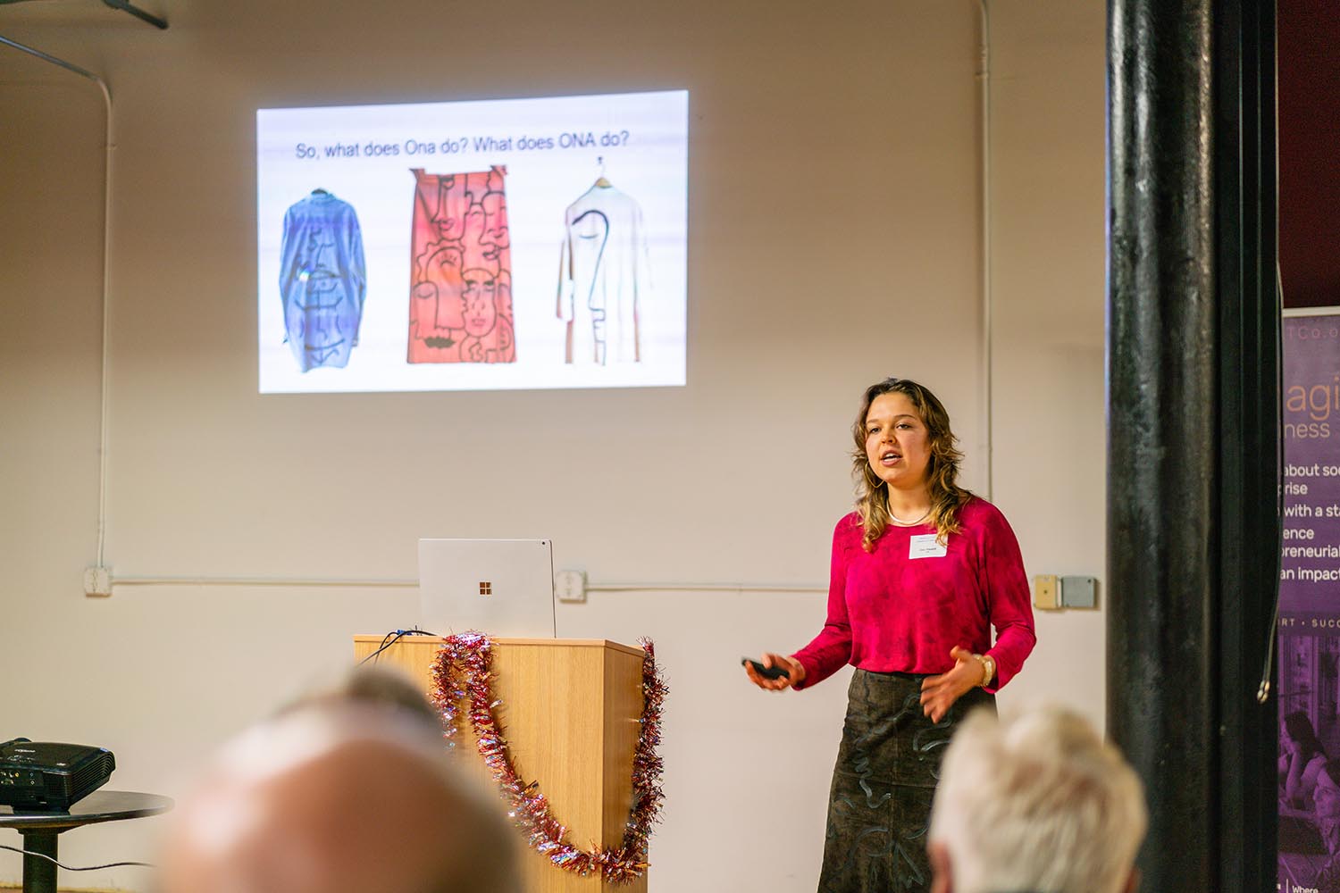 Ona, in front of a slide illustrating clothing, discusses the clothes she designs