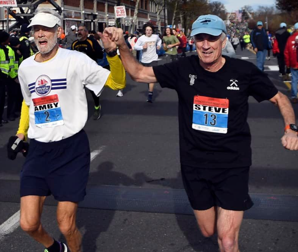 Amby Burfoot '68 (left) finishes his 59th consecutive Manchester Road Race, setting a new record. He finished the race with friend Steve Gates (right).