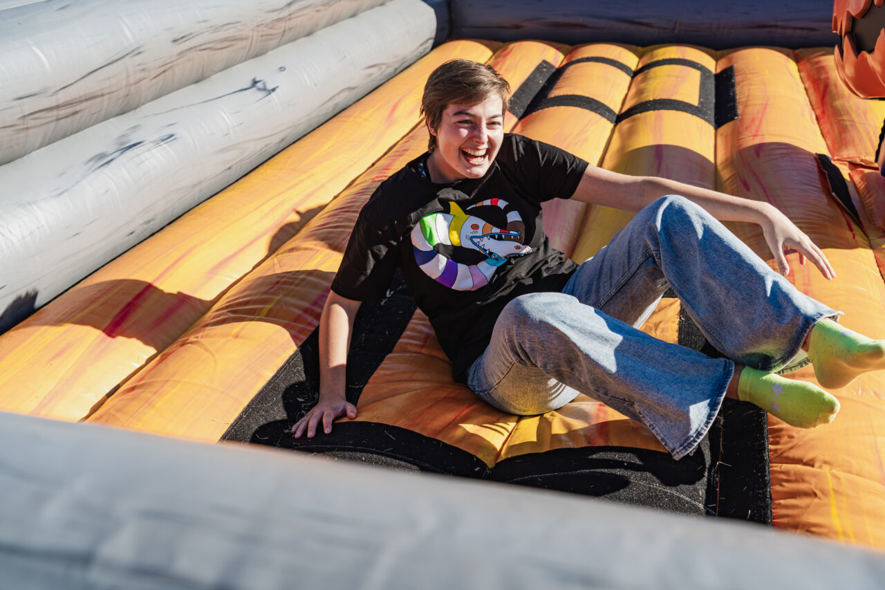 Student rides the mechanical pumpkin at Fall Festival.